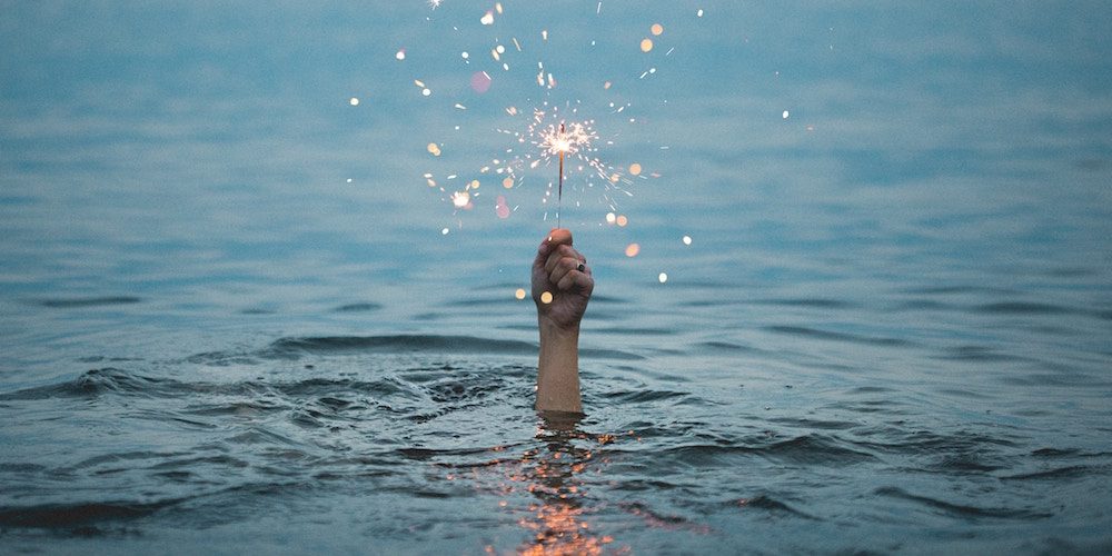 hand rising out of water with sparkler